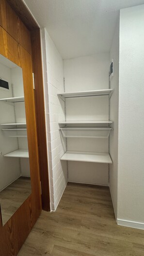 A corner room with white walls, a wooden floor, and built-in white shelving units. - Stressless Sky Vacation Apartment, including the Bavarian Forest AktivCard, Sauna, and Pool (Sankt Englmar)