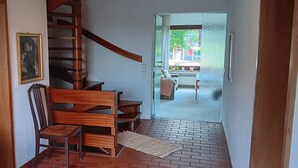Escada que leva a uma sala de estar com sofá e mesa.