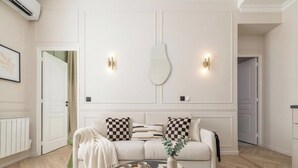 A modern living room with a sofa, a coffee table, and wall-mounted lights.