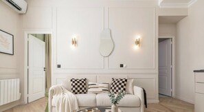 Un salon moderne avec un canapé, une table basse et des lampes fixées au mur.