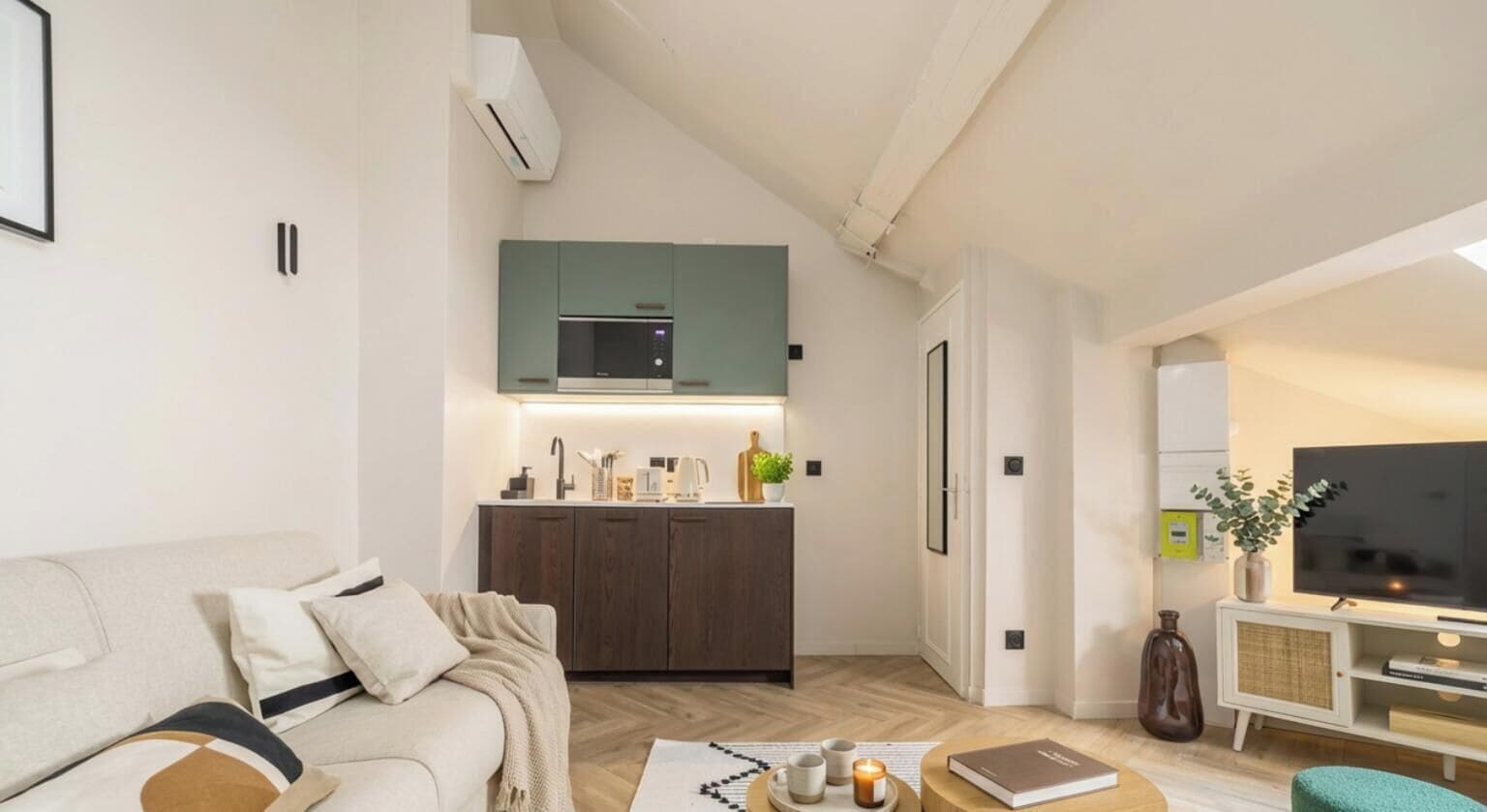 Un salon moderne avec un canapé, une table basse et un téléviseur.