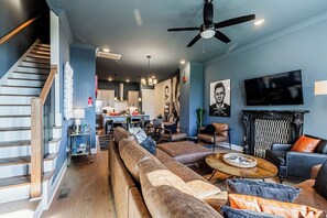 A modern living room with a sofa set, a fireplace, and a television. - Johnny Cash's Ring of Fire Retreat: Rooftop Deck (Nashville)