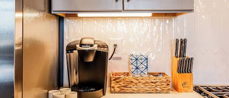 A kitchen with a coffee maker, a knife block, and a woven basket.