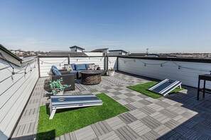 A rooftop patio with a seating area, a small table, and a flat surface. - Johnny Cash's Ring of Fire Retreat: Rooftop Deck (Nashville)