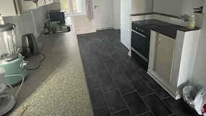 Eine Küche mit eingebautem Backofen, einer Spüle und einem Fenster.