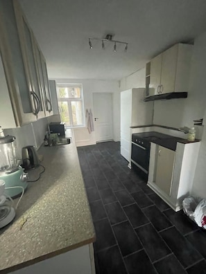 A kitchen with a built-in oven, a sink, and a window.