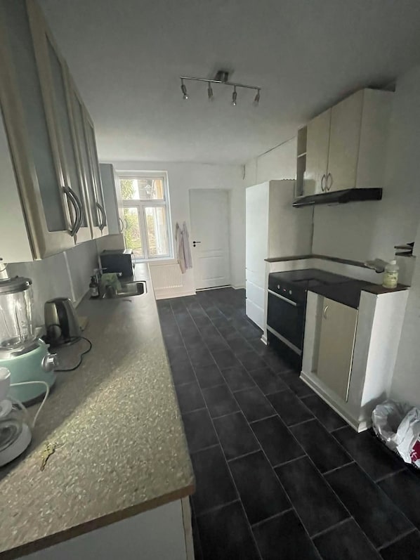 A kitchen with a built-in oven, a sink, and a window.