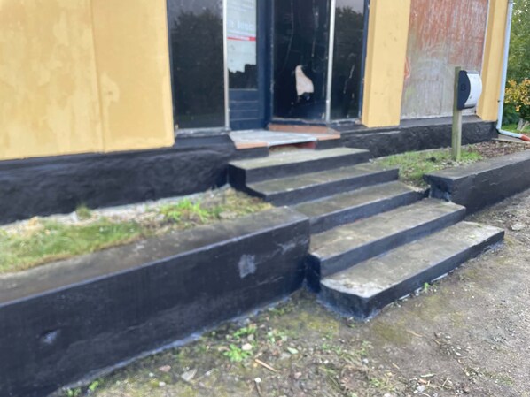 A building with a set of concrete steps leading to a door.