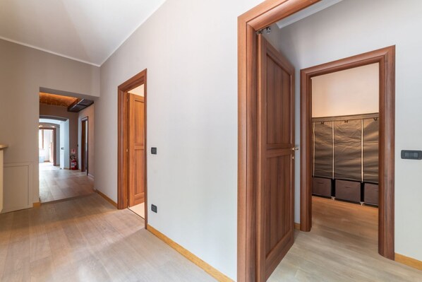 A hallway with wooden doors and a coat rack with hanging items.