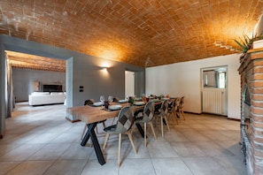A dining area with a brick ceiling, a long wooden table, and chairs. - Exclusive Villa with Swimming Pool and Tennis Area (Frinco)