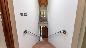A staircase with a wooden ceiling and a view of a balcony.