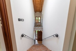 A staircase with a wooden ceiling and a view of a balcony.