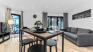 A modern living space with a dining area, a sofa, and a view of the city. - Modern 1 Bedroom Stay Balcony East Croydon (Croydon)