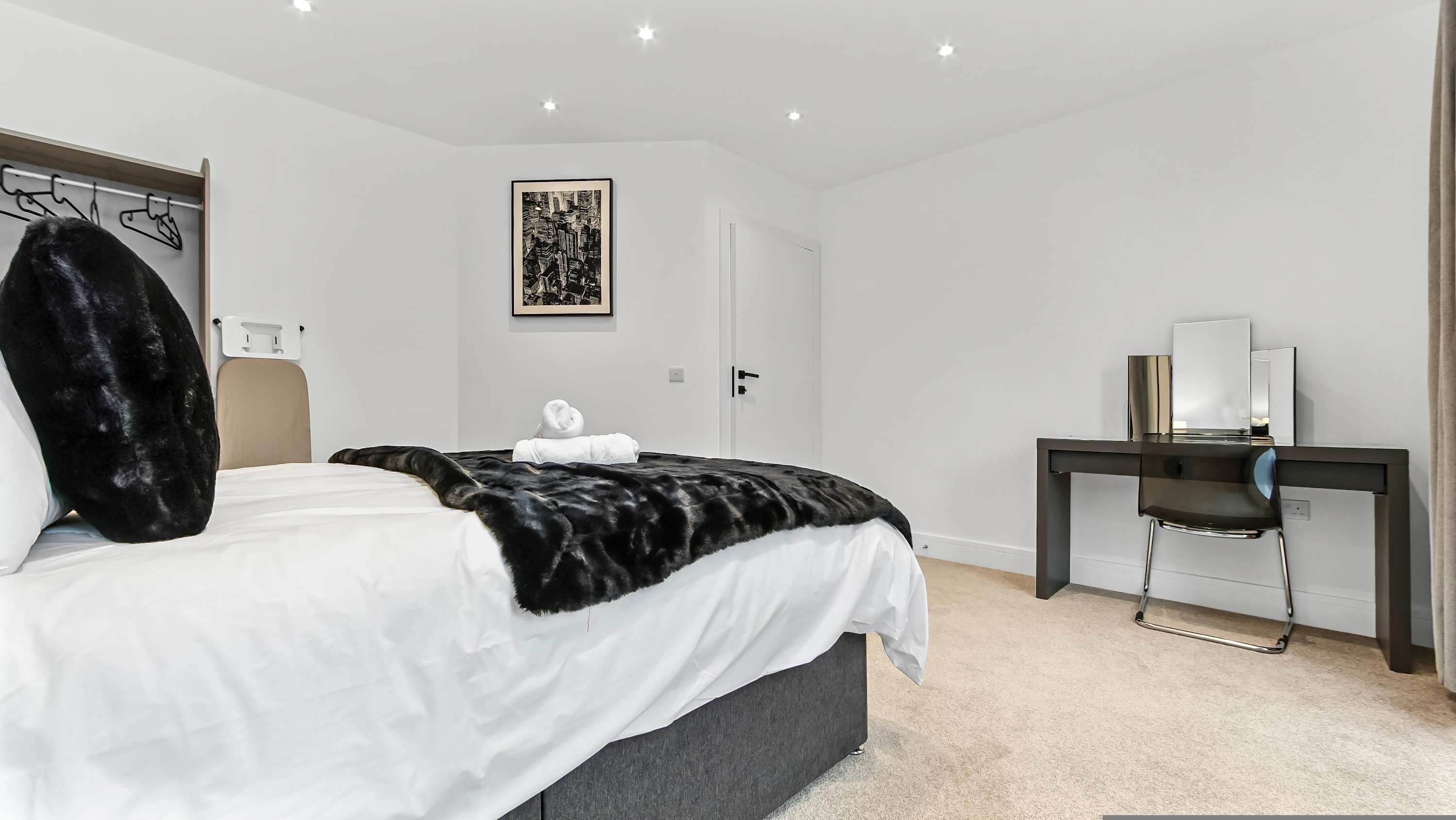Ein modernes Schlafzimmer mit Bett, Schreibtisch und Stuhl.