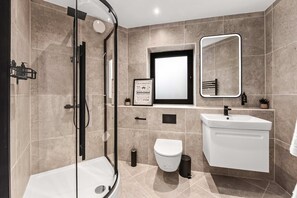 A modern bathroom with a glass shower enclosure, a toilet, a sink, and a mirror. - Modern 2 Bedroom Stay Balcony East Croydon (Croydon)