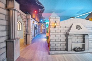 A hallway with a castle-themed design, including stone walls, arched windows, and a colorful ceiling. - 7BR house with private pool in clermont (Clermont)