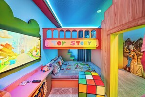 A child's bedroom with a bunk bed, a TV, and a play area. - 7BR house at Windsor Cay Resort (Clermont)