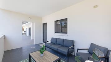 A modern living room with a grey sofa, a wooden coffee table, and a potted plant.