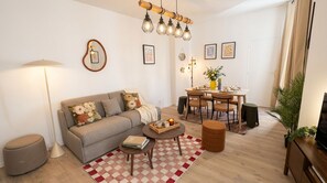 A living room with a sofa, coffee table, and dining table set. - FurtiveStay - Sentier - Ponceau (Paris)