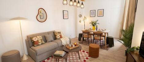 Sala de estar com sofá, mesa de centro e mesa de jantar.