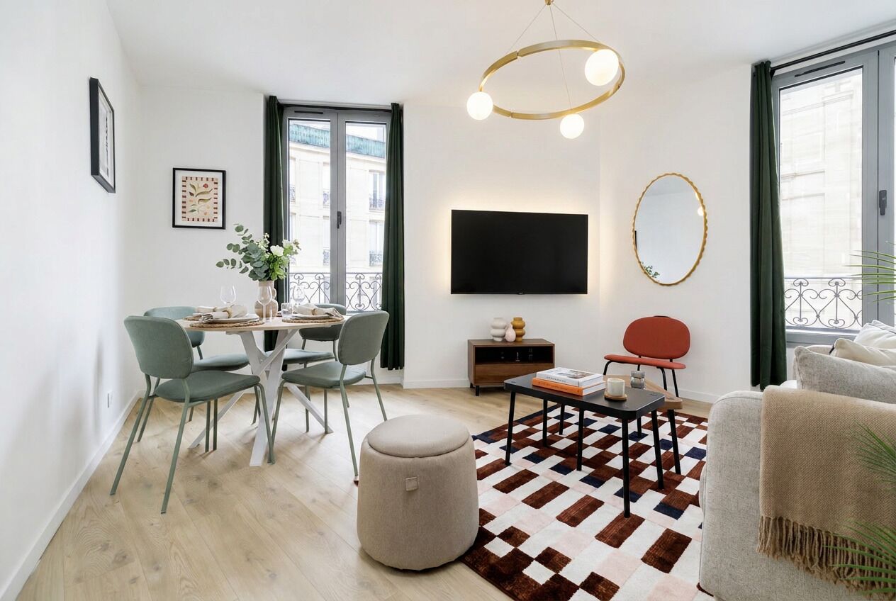 Un salon moderne comprenant un coin repas, un téléviseur à écran plat et une grande fenêtre.