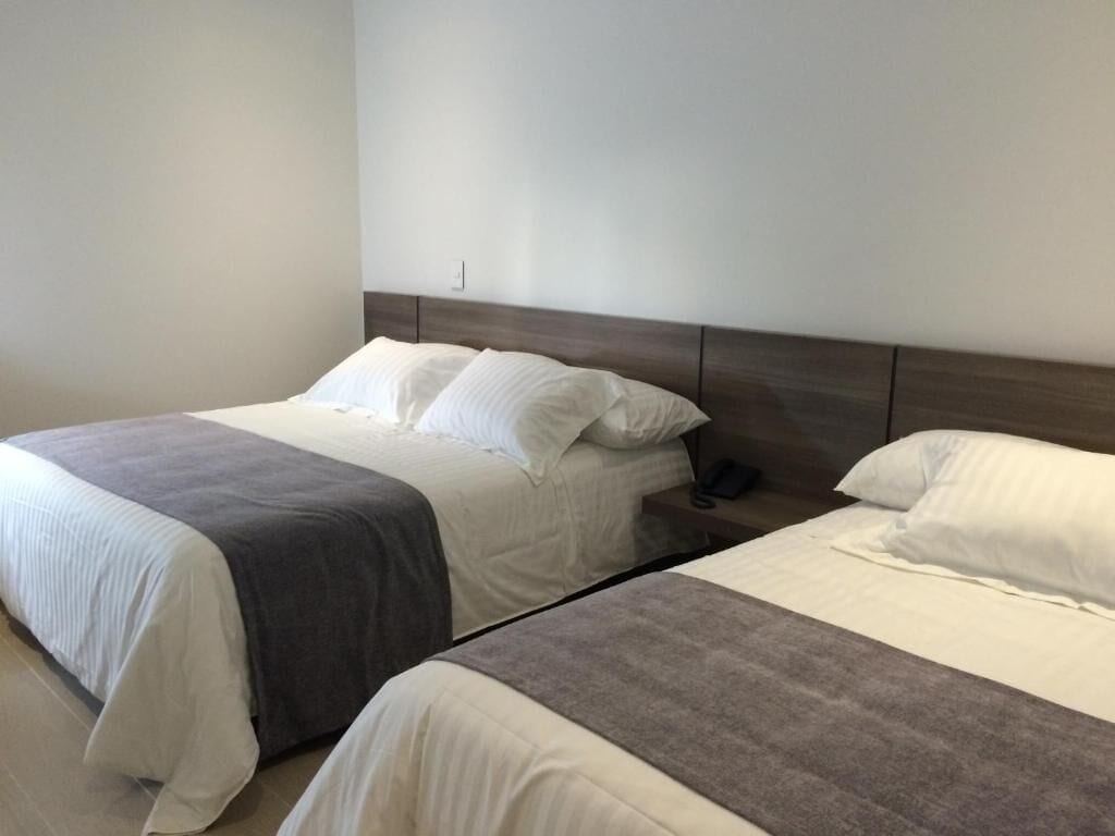 Une chambre d’hôtel avec deux lits, chacun doté d’une tête de lit et d’oreillers.