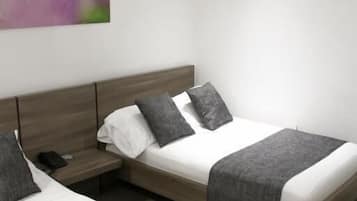 Una habitación de hotel moderna con dos camas, una mesita de noche y un cuadro colgado en la pared.
