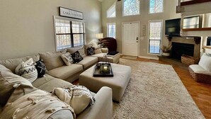 A living room with a beige sofa set, a fireplace, and a ceiling fan. - The Escape on Blade Bay (Hardin County)