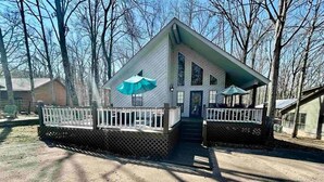 A two-story house with a front porch, a covered entryway, and a small deck area. - The Escape on Blade Bay (Hardin County)