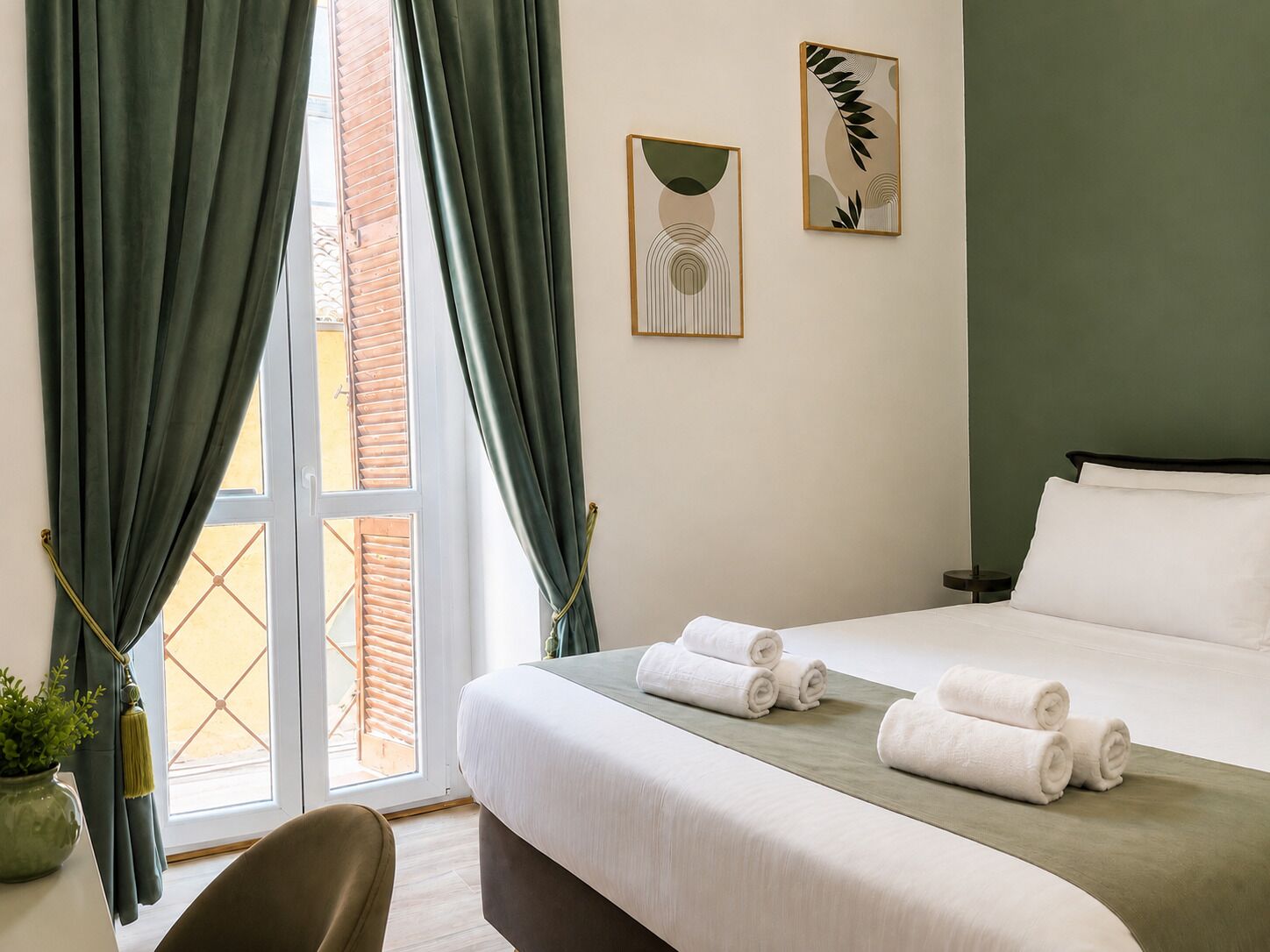 Ein Hotelzimmer mit Bett, Vorhängen, einem Fenster und einem Bild an der Wand.