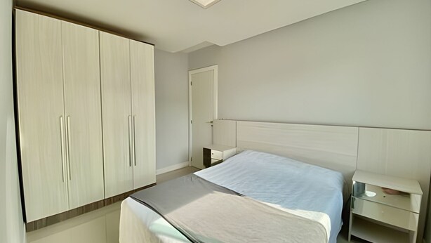 Un dormitorio con cama, armario, mesita de noche y tocador.