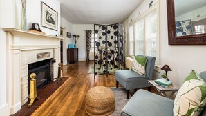 A living room with a fireplace, a sofa, a coffee table, and a decorative mirror. - On Johnson Pond _ Near Downtown and SU (Salisbury)