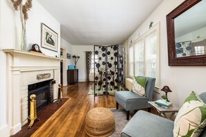A living room with a fireplace, a sofa, a coffee table, and a decorative mirror. - On Johnson Pond _ Near Downtown and SU (Salisbury)