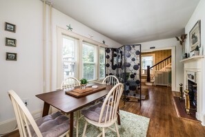 A dining area with a wooden table, chairs, and a decorative plant centerpiece. - On Johnson Pond _ Near Downtown and SU (Salisbury)