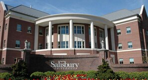 A brick building with a central circular structure, columns, and a sign reading 'Salisbury University'. - On Johnson Pond _ Near Downtown and SU (Salisbury)