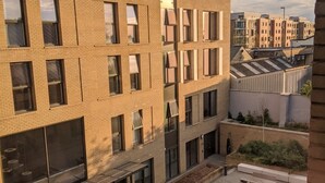 A multi-story building with a courtyard featuring outdoor seating and a fire hydrant. - Student Only Anglia House (Cambridge)