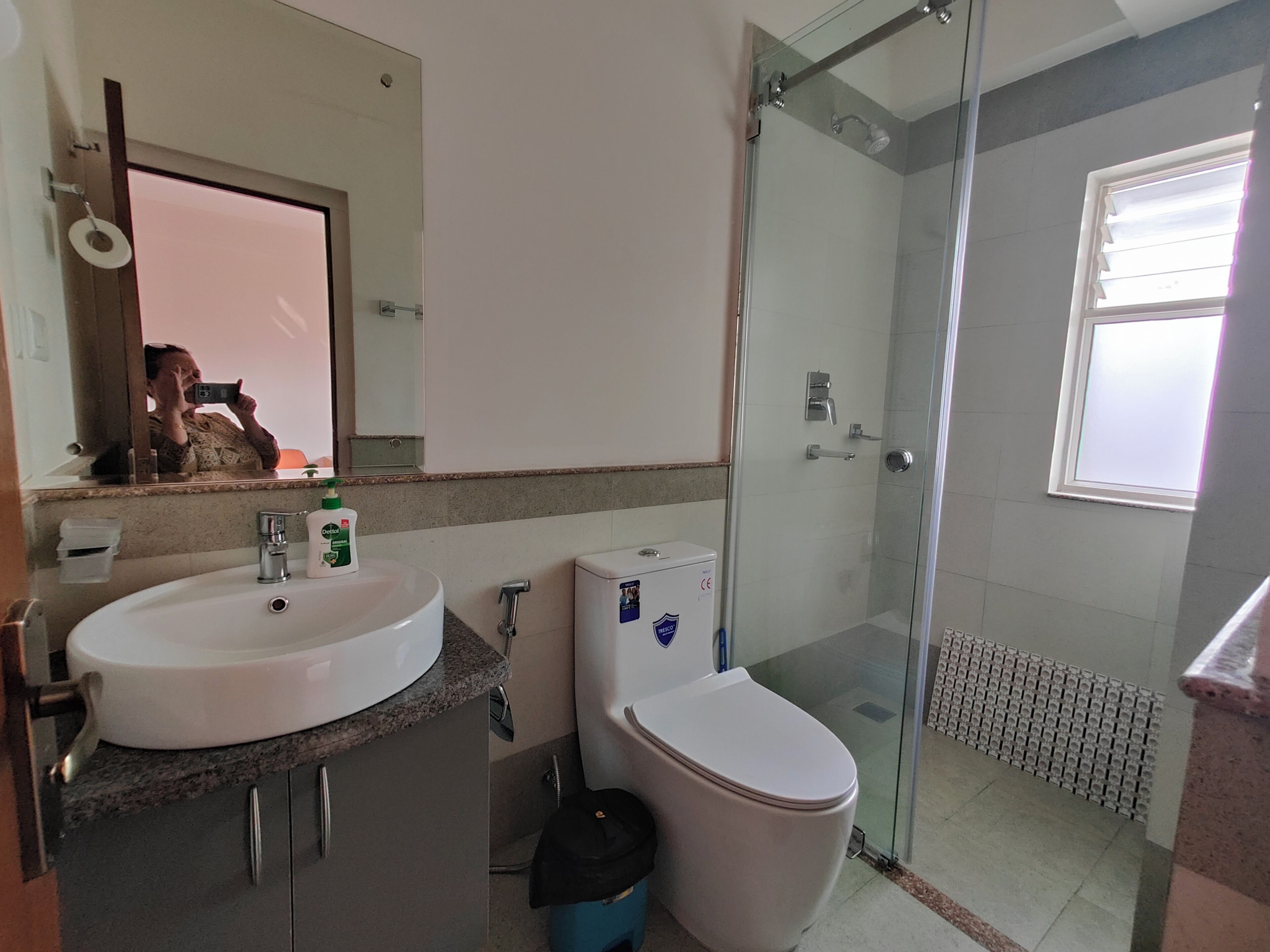 A bathroom with a sink, toilet, and glass shower enclosure.
