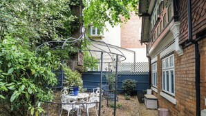 A garden with a metal gazebo, a table, and chairs. - Tudor Lodge (Birmingham)