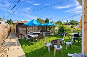 A backyard with a patio area, outdoor furniture, and a covered seating area.
