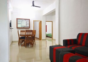 Ein Wohnzimmer mit einer Couch und einem Esstisch mit Stühlen.