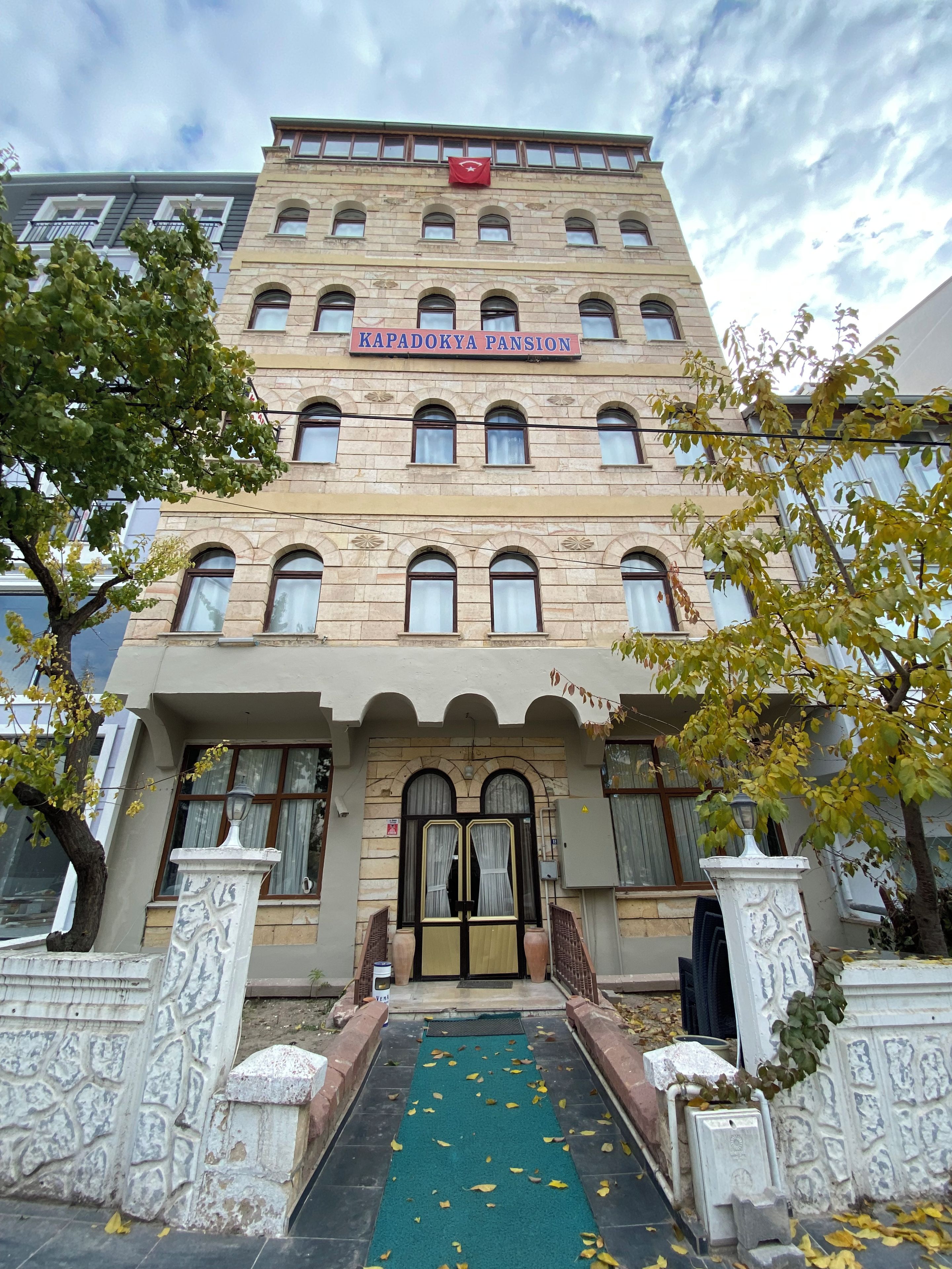 Un edificio de varios pisos con un letrero que dice 'KAPADOKYA PANSION'.