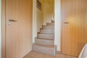 A wooden staircase leading to a landing with a door on each side. - Hus Utblick in Fuhlendorf (Fuhlendorf)