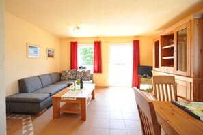 Ein Wohnzimmer mit einer Couch, einem Couchtisch, einem Fernseher und Holzschränken.