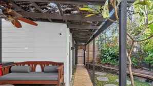 A covered outdoor seating area with a wooden bench and a ceiling fan. - Kingsley Discover Cafs Street Art and Village Life (Newtown)