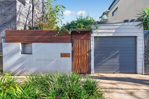 A residential garage with a wooden gate and a garage door. - Kingsley Discover Cafs Street Art and Village Life (Newtown)
