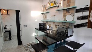 A modern kitchen with a central island, bar stools, and a backsplash with various tiles.