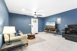 A living room with a sofa, coffee table, TV, and a fireplace.