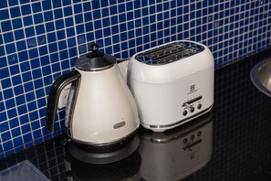 A kitchen with a white kettle and a toaster on a black countertop. - Skyline Terrace Central CBD Escape with City Views (Melbourne)