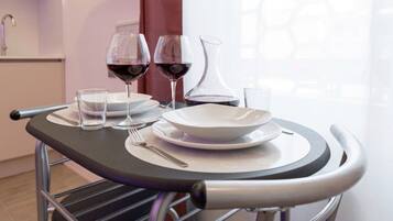 A table with a wine glass, a water glass, and a white bowl set on a tray.