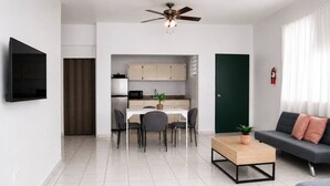 Una sala de estar moderna con sofá, mesa de centro y televisor.